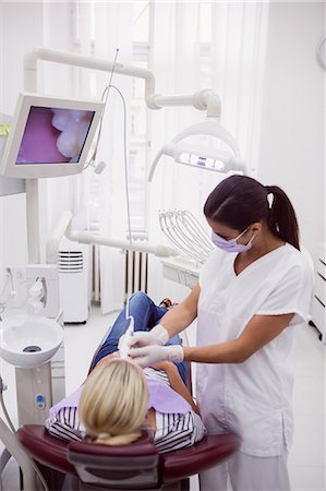 dentist with patient in exam room - Female dentist examining patient in dental clinic Stock Photo - Premium Royalty-Free, Code: 6109-08803998