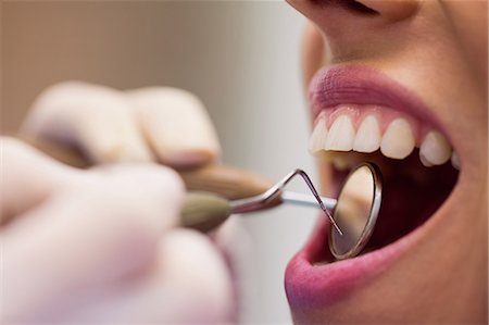 dentist with patient in exam room - Close-up of dentist examining a female patient with tools at dental clinic Stock Photo - Premium Royalty-Free, Code: 6109-08803921