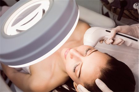 simsearch:6109-08804015,k - Doctor giving facial massage to patient through sonic lifting in clinic Stock Photo - Premium Royalty-Free, Code: 6109-08804042