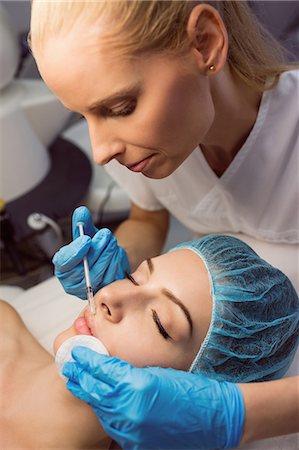 simsearch:6109-08804015,k - Female patient receiving an injection on her face in clinic Stock Photo - Premium Royalty-Free, Code: 6109-08804048