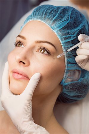 Close-up of female patient receiving an injection on her face in clinic Stock Photo - Premium Royalty-Free, Code: 6109-08804052