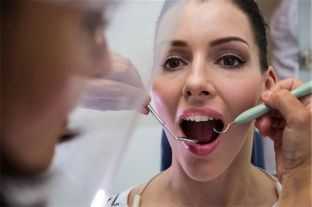 simsearch:649-07063763,k - Dentist examining a female patient with tools at dental clinic Stock Photo - Premium Royalty-Free, Code: 6109-08804069