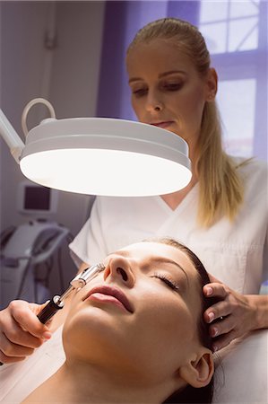 simsearch:6109-08804015,k - Dermatologist performing laser hair removal on patient face in clinic Stock Photo - Premium Royalty-Free, Code: 6109-08804013