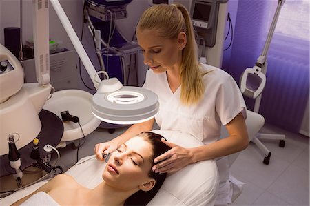simsearch:6109-08804015,k - Dermatologist performing laser hair removal on patient face in clinic Stock Photo - Premium Royalty-Free, Code: 6109-08804012