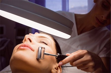 simsearch:6109-08804015,k - Dermatologist performing laser hair removal on patient face in clinic Stock Photo - Premium Royalty-Free, Code: 6109-08804021
