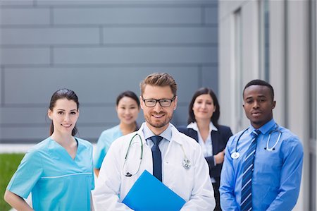 simsearch:6109-08804356,k - Portrait of smiling doctors standing together in hospital premises Stock Photo - Premium Royalty-Free, Code: 6109-08804340