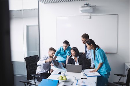 simsearch:6109-08804356,k - Medical team examining an x-ray report in conference room Stock Photo - Premium Royalty-Free, Code: 6109-08804383