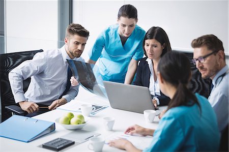 simsearch:6109-08804356,k - Team of doctor discussing over laptop in meeting at conference room Stock Photo - Premium Royalty-Free, Code: 6109-08804381
