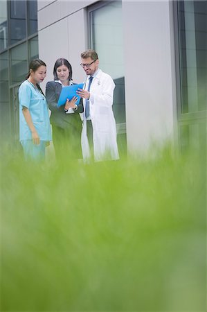 simsearch:6109-08804356,k - Doctors and nurse discussing over report in hospital premises Stock Photo - Premium Royalty-Free, Code: 6109-08804327