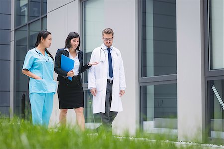 simsearch:6109-08804356,k - Doctors and nurse interacting while walking in hospital premises Stock Photo - Premium Royalty-Free, Code: 6109-08804328