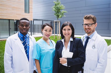 simsearch:6109-08804356,k - Portrait of smiling doctors standing together in hospital premises Stock Photo - Premium Royalty-Free, Code: 6109-08804332