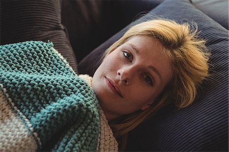 Portrait of beautiful woman lying on sofa in living room at home Stock Photo - Premium Royalty-Free, Code: 6109-08804670