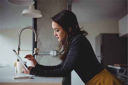 Woman using digital tablet in kitchen at home Stockbilder - Premium RF Lizenzfrei, Bildnummer: 6109-08804744