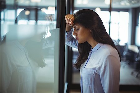 simsearch:6109-08203934,k - Upset businesswoman leaning against door in offic Stock Photo - Premium Royalty-Free, Code: 6109-08805035