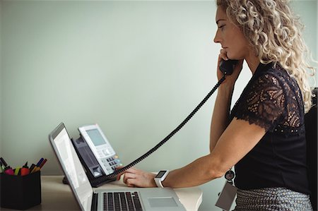 Businesswoman talking on landline Stock Photo - Premium Royalty-Free, Code: 6109-08829583