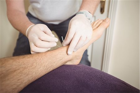 Physiotherapist performing dry needling on the leg of a patient Stock Photo - Premium Royalty-Free, Code: 6109-08829774