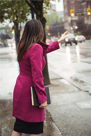 Businesswoman hailing a taxi cab Stock Photo - Premium Royalty-Free, Code: 6109-08830081