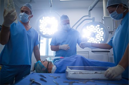 surgical tools on tray - Group of surgeons performing operation in operation room Stock Photo - Premium Royalty-Free, Code: 6109-08830004