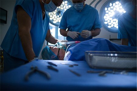 surgical tools on tray - Group of surgeons performing operation in operation room Stock Photo - Premium Royalty-Free, Code: 6109-08830005