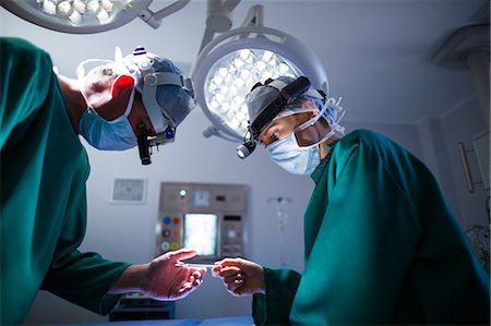 simsearch:649-06000982,k - Surgeons wearing surgical loupes while performing operation Stock Photo - Premium Royalty-Free, Code: 6109-08830151