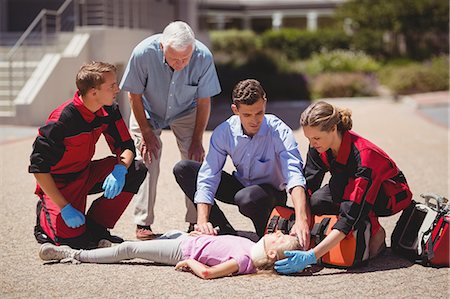 Paramedics examining injured girl Stock Photo - Premium Royalty-Free, Code: 6109-08830414