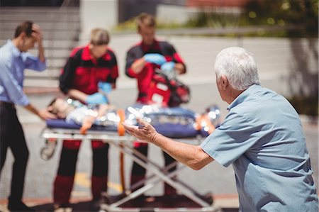 respiration (medical assisted breathing) - Paramedics examining injured boy Stock Photo - Premium Royalty-Free, Code: 6109-08830422