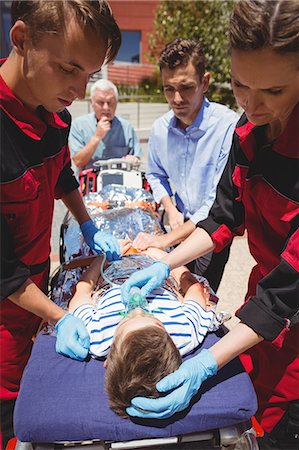 respiration (medical assisted breathing) - Paramedics examining injured boy Stock Photo - Premium Royalty-Free, Code: 6109-08830426