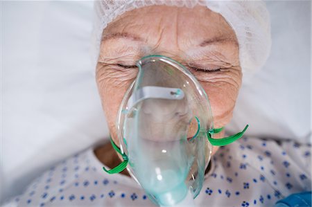 simsearch:6113-06908191,k - Senior patient wearing oxygen mask lying on hospital bed Stock Photo - Premium Royalty-Free, Code: 6109-08830430