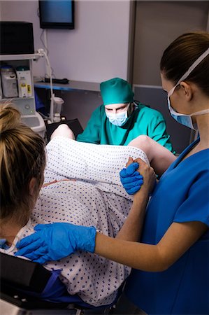 Medical team examining pregnant woman during delivery Photographie de stock - Premium Libres de Droits, Code: 6109-08830567