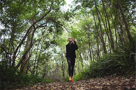 simsearch:400-04535435,k - Woman jogging in forest Stock Photo - Premium Royalty-Free, Code: 6109-08830631