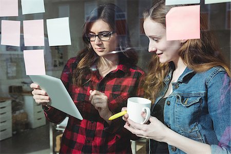 Business executives discussing over digital tablet while having cup of coffee Stock Photo - Premium Royalty-Free, Code: 6109-08830725