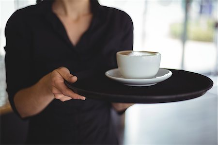 food and beverages hotel uniforms - Mid section of waitress standing with cup of coffee in cafe Stock Photo - Premium Royalty-Free, Code: 6109-08944149
