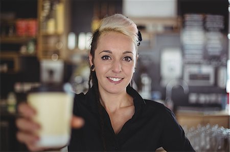 pretty workers at a hotel - Portrait of waitress standing with disposable coffee cup in café Stock Photo - Premium Royalty-Free, Code: 6109-08944156