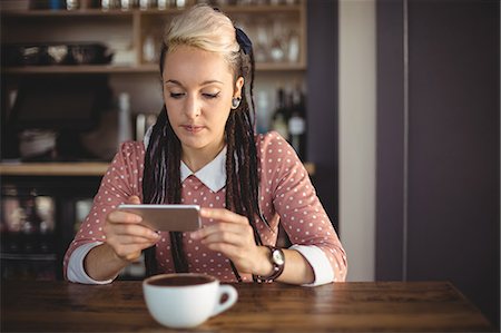 simsearch:6109-08690411,k - Woman using mobile phone in café Stock Photo - Premium Royalty-Free, Code: 6109-08944179