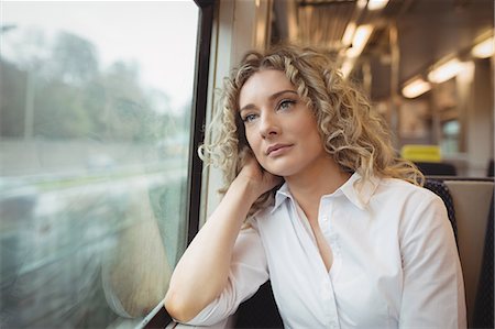 Thoughtful woman looking out through train window Stock Photo - Premium Royalty-Free, Code: 6109-08944320