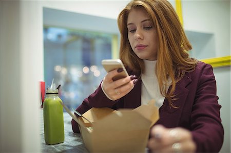 snack shop - Woman taking picture of salad on mobile phone in the restaurant Stock Photo - Premium Royalty-Free, Code: 6109-08944421