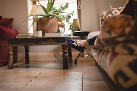 simsearch:6109-07497438,k - Girl sitting on sofa in living room at home Stock Photo - Premium Royalty-Free, Code: 6109-08944536