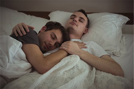 Gay couple embracing while sleeping on bed in bedroom Stock Photo - Premium Royalty-Free, Code: 6109-08944652