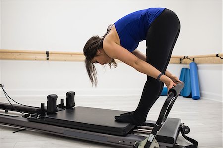 simsearch:6108-06906954,k - Woman exercising on reformer in gym Stock Photo - Premium Royalty-Free, Code: 6109-08944777