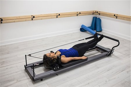 simsearch:6108-06906954,k - Woman exercising on reformer in gym Stock Photo - Premium Royalty-Free, Code: 6109-08944793