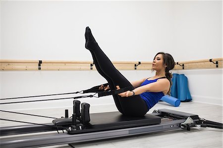 simsearch:6108-06906954,k - Woman exercising on reformer in gym Stock Photo - Premium Royalty-Free, Code: 6109-08944791