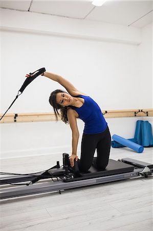 simsearch:6108-06906954,k - Woman exercising on reformer in gym Stock Photo - Premium Royalty-Free, Code: 6109-08944792