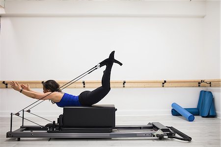 simsearch:6108-06906954,k - Woman exercising on reformer in gym Stock Photo - Premium Royalty-Free, Code: 6109-08944797