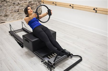 simsearch:6108-06906954,k - Woman exercising with pilates ring in gym Stock Photo - Premium Royalty-Free, Code: 6109-08944794