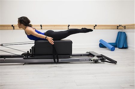 simsearch:6108-06906954,k - Woman exercising on reformer in gym Stock Photo - Premium Royalty-Free, Code: 6109-08944796