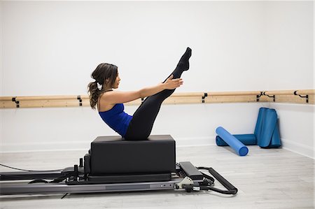 simsearch:6108-06906954,k - Woman exercising on reformer in gym Stock Photo - Premium Royalty-Free, Code: 6109-08944798