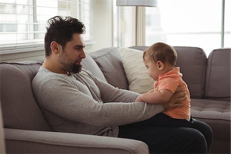 simsearch:700-06758135,k - Father playing with his baby on sofa in living room at home Stock Photo - Premium Royalty-Free, Code: 6109-08944701