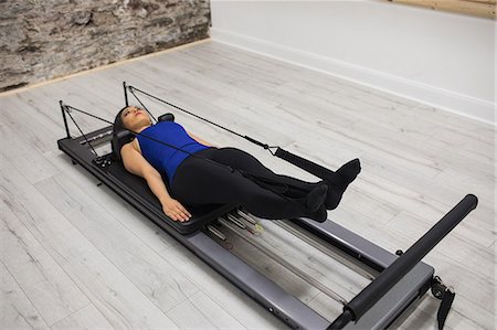 simsearch:6108-06906954,k - Woman exercising on reformer in gym Stock Photo - Premium Royalty-Free, Code: 6109-08944804