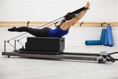 simsearch:6108-06906954,k - Woman exercising on reformer in gym Stock Photo - Premium Royalty-Free, Code: 6109-08944813