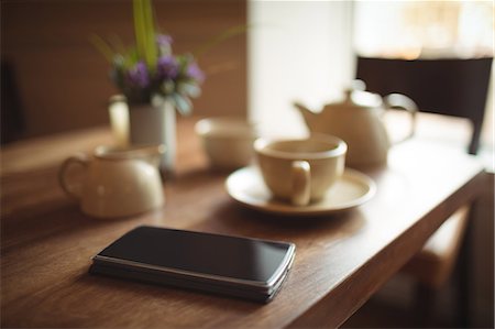 simsearch:6109-08690411,k - Mobile phone and coffee cup on wooden table in café Stock Photo - Premium Royalty-Free, Code: 6109-08944962
